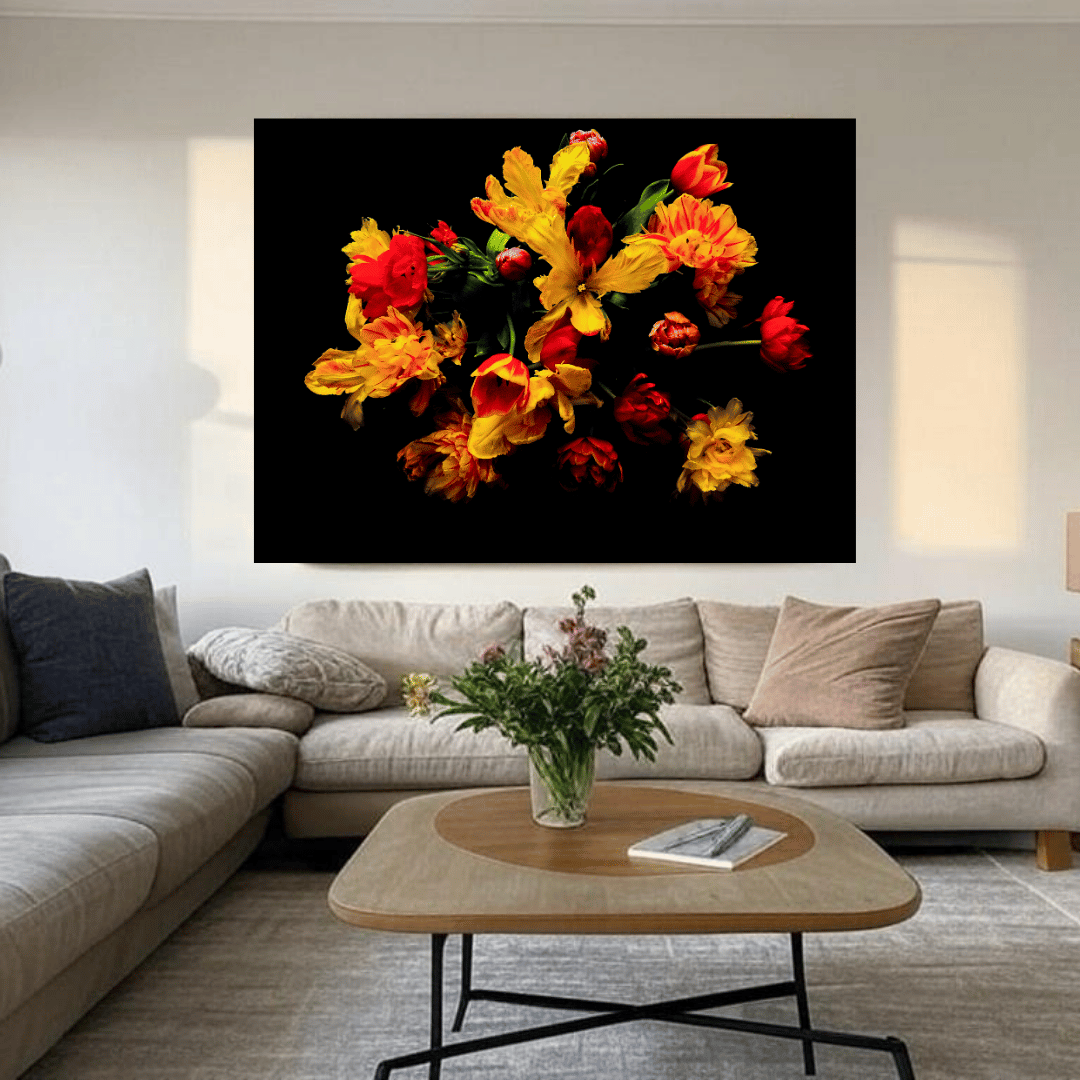 Kleurrijke bloemenposter met rood en geel op zwarte achtergrond, boven beige hoekbank in modern interieur.