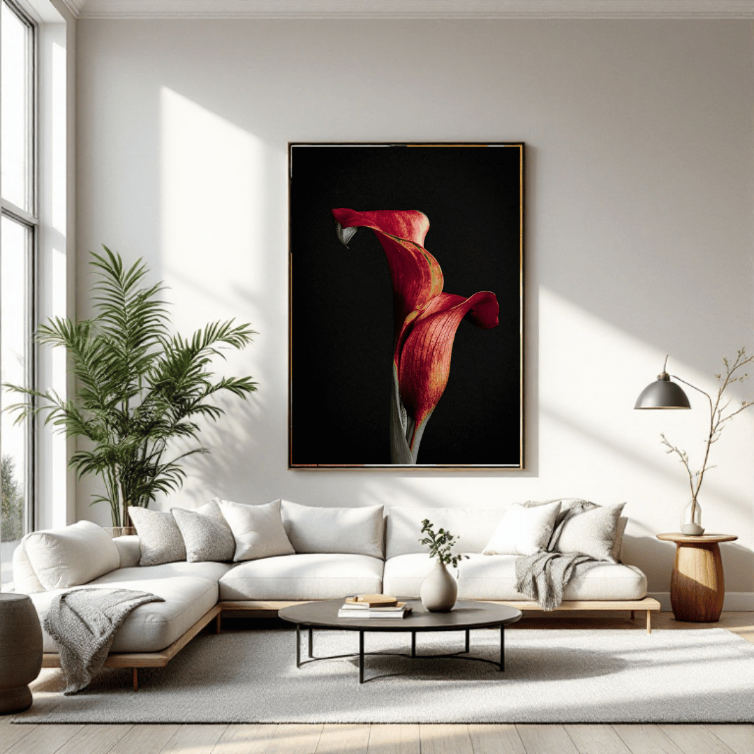 Grote rode calla lelie kunstprint boven beige hoekbank in moderne woonkamer met natuurlijk licht, groene plant en minimalistische inrichting