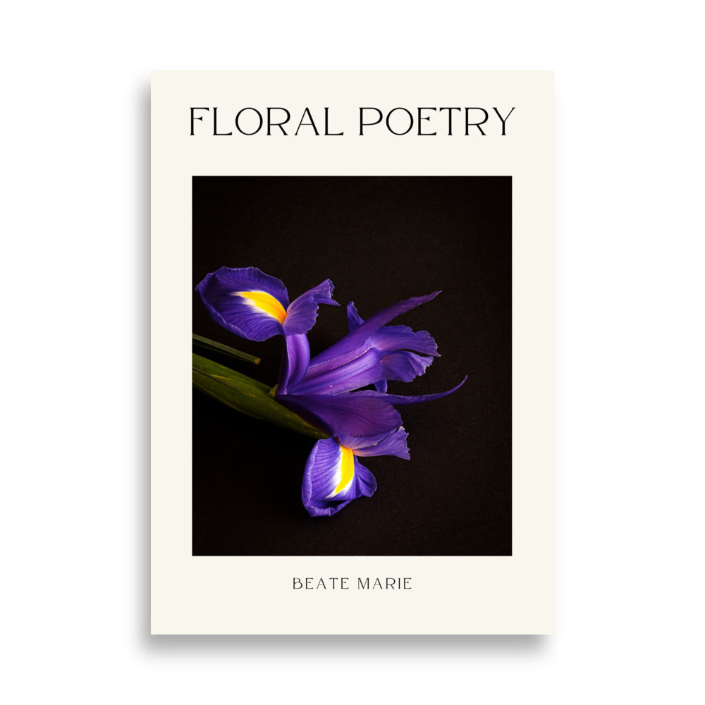 Kunstfoto getiteld "FLORAL POETRY" toont een paarse iris tegen een zwarte achtergrond. De bloem heeft opvallende gele accenten in het hart. Groene stengel zichtbaar. De foto is omlijst door een witte rand met de titel bovenaan en de naam "BEATE MARIE" onderaan. 50x70 cm